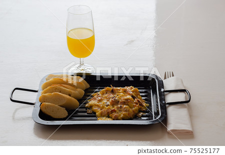 Scrambled eggs served with orange juice and fresh baguette Scrambled eggs served with orange juice and fresh baguette 75525177