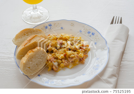 Scrambled eggs served with orange juice and fresh baguette 75525195