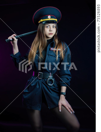 a woman in a Russian police uniform with a baton. English translation Police 75526893