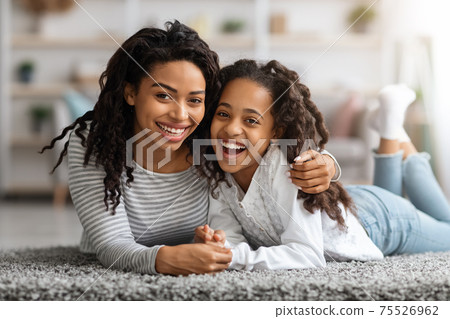 Adorable african american mother and daughter bonding on carpet 75526962