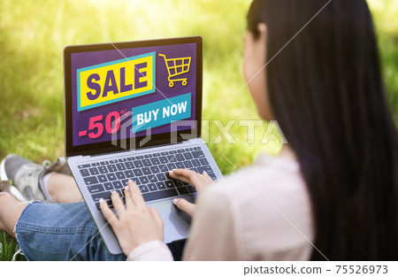 Young lady resting outdoors, shopping online, using laptop Young lady resting outdoors, shopping online, using laptop 75526973