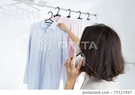 Woman hanging laundry in the bathroom Woman hanging laundry in the bathroom 75527497