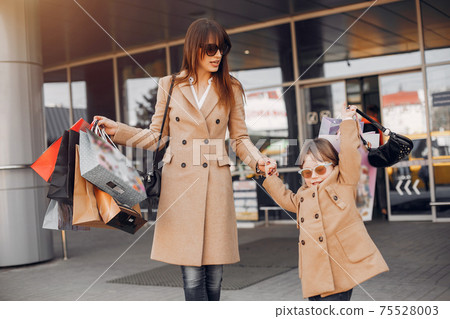 Mother and daughter with shopping bag in a city Mother and daughter with shopping bag in a city 75528003