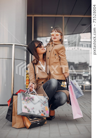 Mother and daughter with shopping bag in a city Mother and daughter with shopping bag in a city 75528004