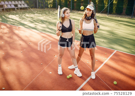Beautiful and stylish girls on the tennis court 75528129