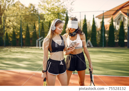 Beautiful and stylish girls on the tennis court 75528132