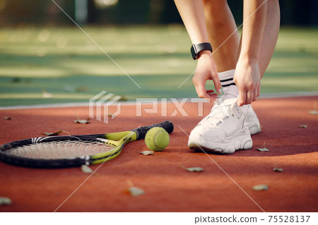 Beautiful and stylish girl on the tennis court 75528137