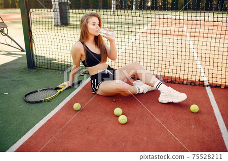 Beautiful and stylish girl on the tennis court 75528211