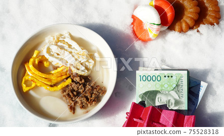 Rice cake soup, okchun candy, and medicine with winter snow in the background 75528318