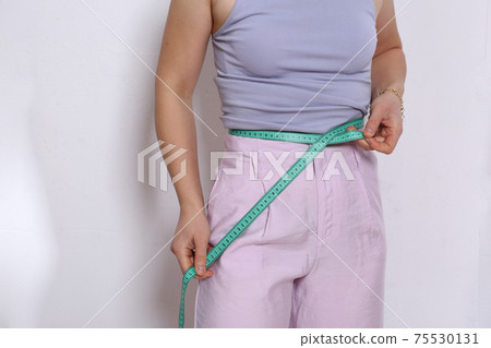 woman with measure band closeup photo on white wall background woman with measure band closeup photo on white wall background 75530131