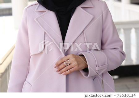 pink woolen coat closeup detail with model hands on city street background pink woolen coat closeup detail with model hands on city street background 75530134