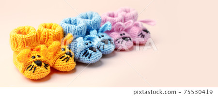 Set of small yellow baby socks on pastel background, copy space for your warm message, baby shower, first newborn party background, banner. Mother mom day oncept, funny bunny booties Set of small yellow baby socks on pastel background, copy space for your warm message, baby shower, first newborn party background, banner. Mother mom day oncept, funny bunny booties 75530419