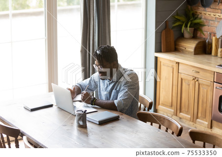 Confident black guy hold virtual business meeting online using laptop 75533350