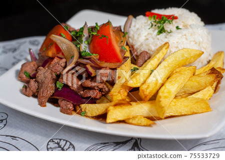 Peruvian traditional food. A beef with tomatoes, onion, rice and fried potatoes, Lomo saltado Peruvian traditional food. A beef with tomatoes, onion, rice and fried potatoes, Lomo saltado 75533729