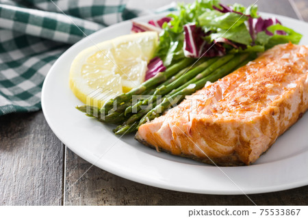 Grilled salmon fillet with asparagus and salad 75533867