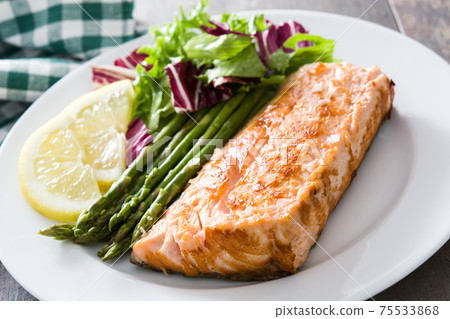 Grilled salmon fillet with asparagus and salad 75533868