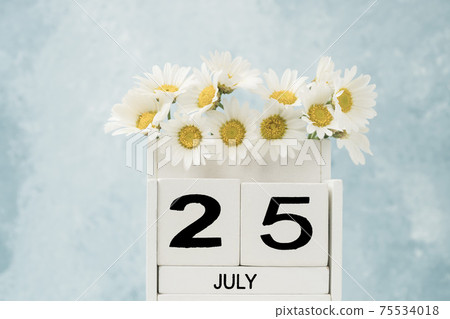 White cube calendar for july decorated with daisy flowers 75534018