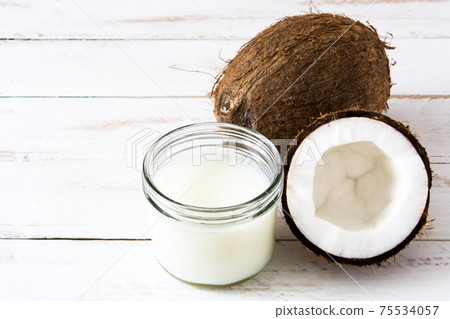 Coconut and coconut milk on whiote wooden table. Copy space Coconut and coconut milk on whiote wooden table. Copy space 75534057