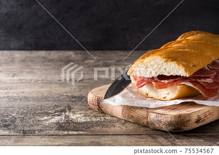 Spanish serrano ham sandwich on wooden table Spanish serrano ham sandwich on wooden table 75534567