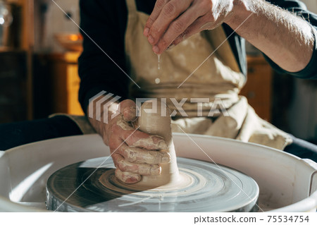 Sculptor in the workshop makes a jug out of earthenware Sculptor in the workshop makes a jug out of earthenware 75534754