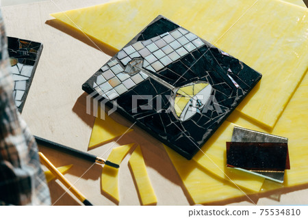 Table of artist with mosaic from the glass laying with pieces for future mosaic 75534810