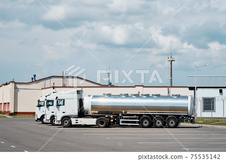 Trucks with tank trailer on parking lot 75535142