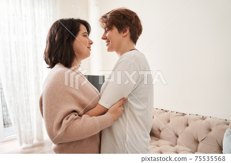 Girl keeping smile on her face while standing close to her female partner 75535568