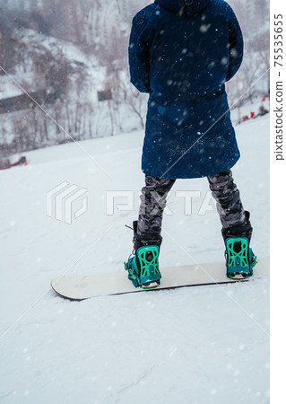 Back view of snowboarder standing on ski slope and enjoying mountain landscape. Winter spor, outdoor activities Back view of snowboarder standing on ski slope and enjoying mountain landscape. Winter spor, outdoor activities 75535655