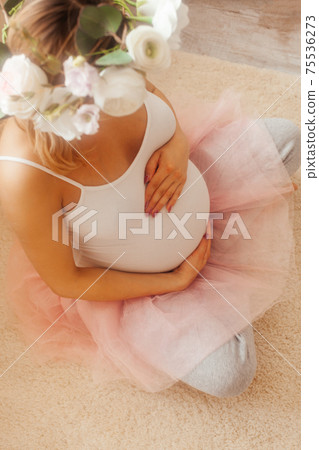 Pregnant woman stay in the room and look at the belly 75536273