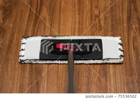 White mop washes wooden floor close up 75536502