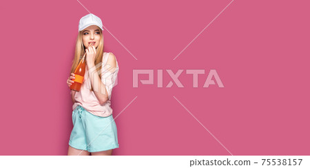 Sporty woman with cold drink standing on pink background 75538157