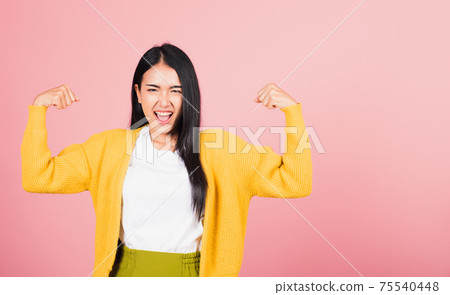 woman raises arms biceps confident showing power woman raises arms biceps confident showing power 75540448