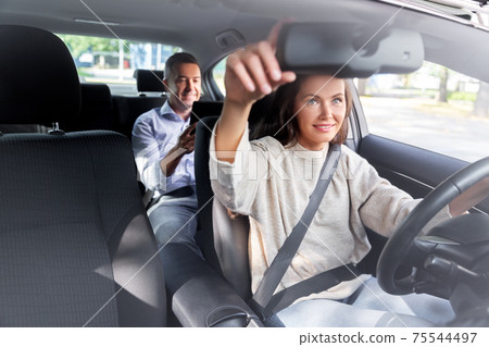 female driver driving car with male passenger 75544497