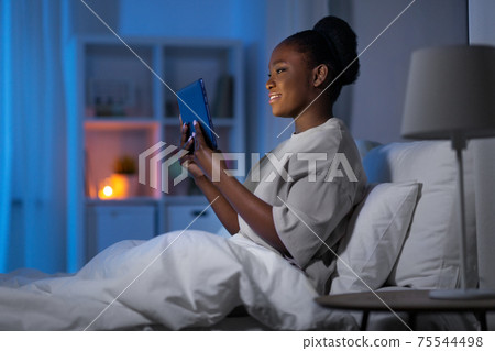 woman with tablet pc in bed at home at night woman with tablet pc in bed at home at night 75544498