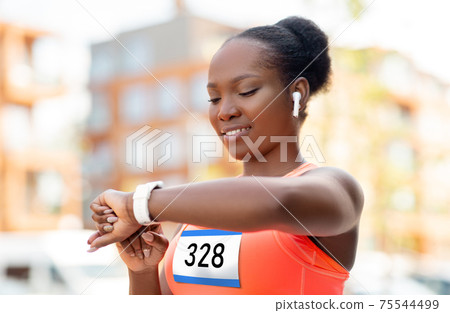 marathon runner with earphones and smart watch marathon runner with earphones and smart watch 75544499