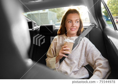 smiling woman or passenger drinking coffee in car 75544978