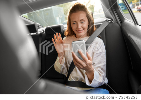 happy woman in car having video call on smartphone 75545253