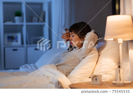 tired asian woman stretching in bed at night tired asian woman stretching in bed at night 75545535