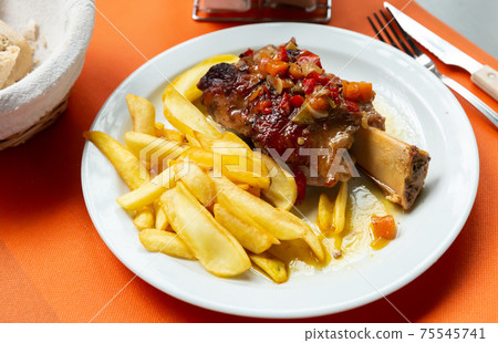 Pork baked shank with vegetables and french fries served Pork baked shank with vegetables and french fries served 75545741