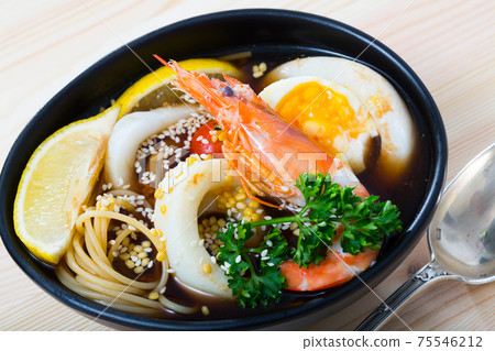 Asian cuisine spicy soup with squid 75546212