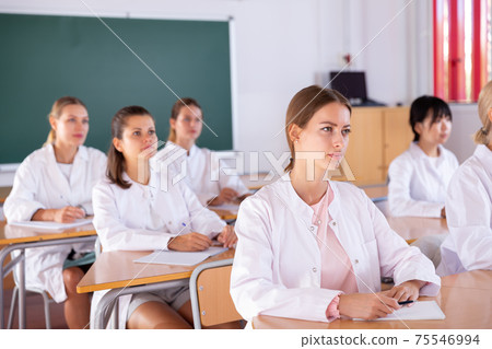 Medical students writing in notepads 75546994