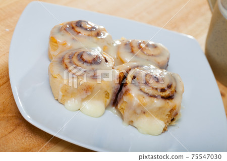 Rolled cinnamon buns on white plate Rolled cinnamon buns on white plate 75547030