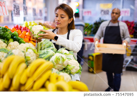 Supermarket workers in fruit and vegetables section Supermarket workers in fruit and vegetables section 75547095