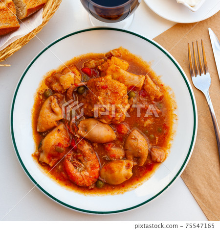 Close up of traditional spanish zarzuela on white plate on white tablecloth 75547165