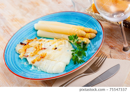 Deliciously roasted halibut fillet with asparagus and greens Deliciously roasted halibut fillet with asparagus and greens 75547337