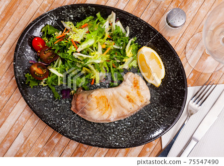 Fried porbeagle steak with vegetable salad and lemon wedge Fried porbeagle steak with vegetable salad and lemon wedge 75547490