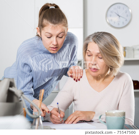 Woman filling bills at home 75547500