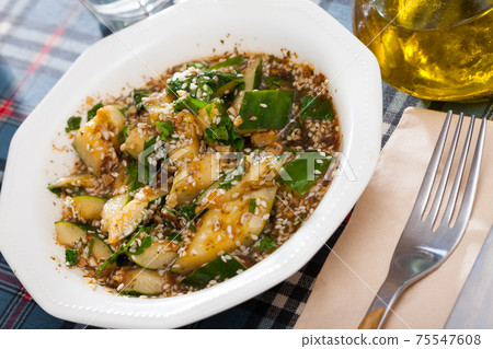 Salad of broken cucumbers with sesame seeds, sugar, red and black pepper, olive oil Salad of broken cucumbers with sesame seeds, sugar, red and black pepper, olive oil 75547608