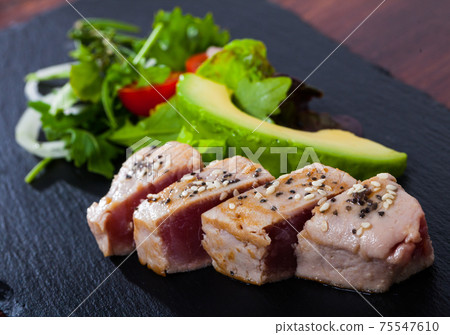 Slightly fried tuna with avocado and greens Slightly fried tuna with avocado and greens 75547610
