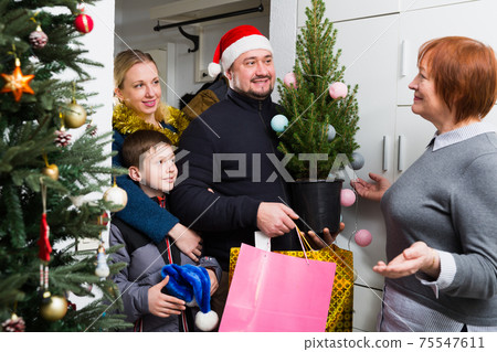 Adult son with family visiting mother at Christmas 75547611